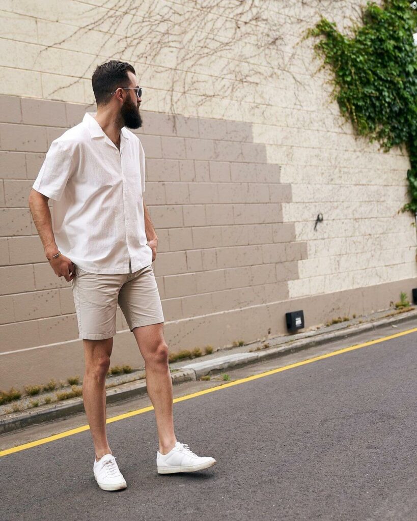 man wearing khaki shorts outdoor with white sleeveless shirt and white sneakers
