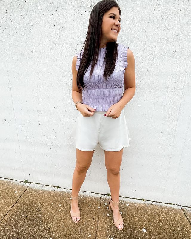 Woman wearing lavender top with  white shorts