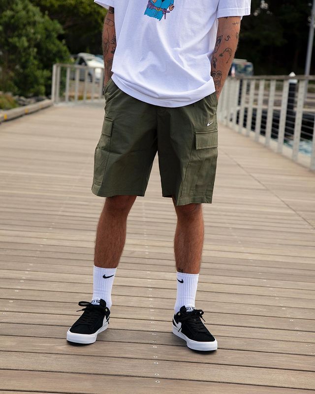 man wearing black sneakers with cargo shorts