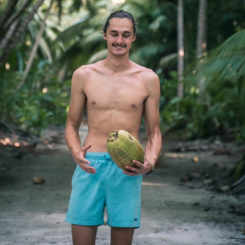 man wearing teal beach shorts