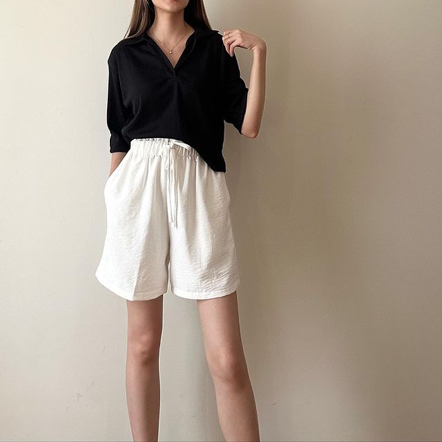 Girl wearing black top with  white shorts