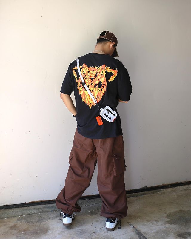 Man in black graphic t-shirt  and cargo pants